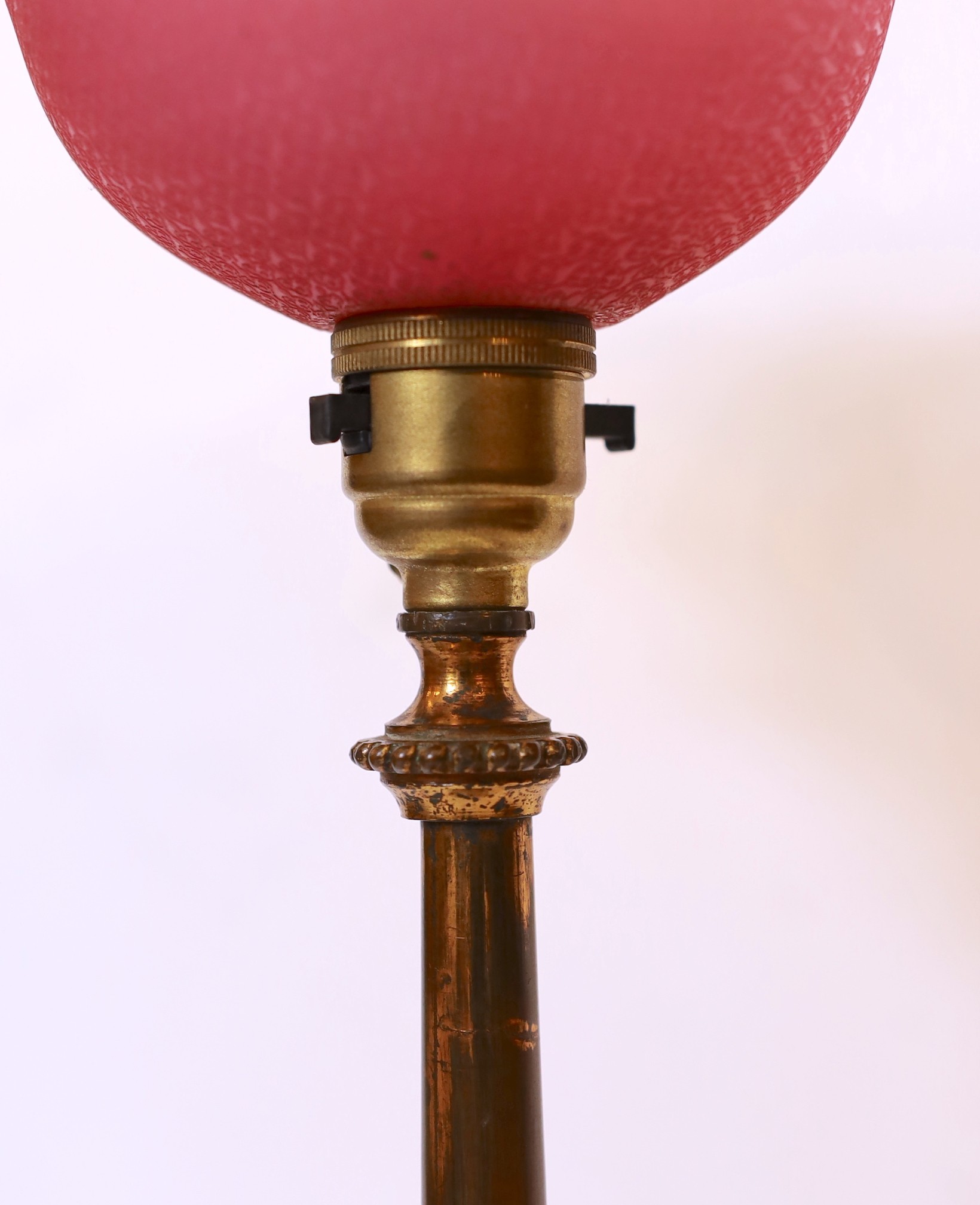 A late 19 century English lacquered bronze and glass table lamp with edged pink glass shade, height overall 51cm